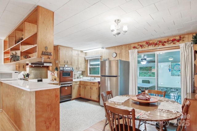 51 Atari Rd, Waynesville, NC 28786 - kitchen with white microwave, freestanding refrigerator, light countertops, a sink, and a peninsula