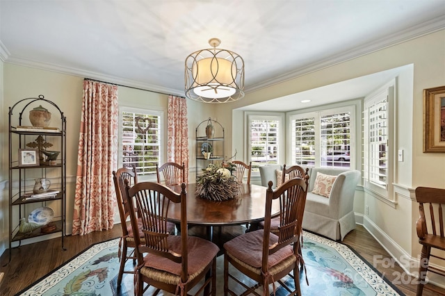 dining area featuring ornamental molding, wood finished floors, baseboards, and a chandelier