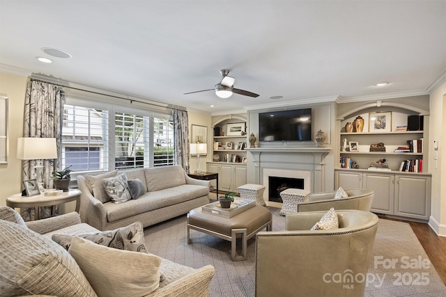 living room featuring crown molding, ceiling fan, a fireplace, wood finished floors, and recessed lighting