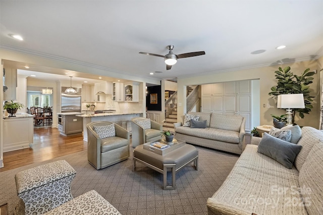living room featuring crown molding, wood finished floors, stairway, a ceiling fan, and recessed lighting