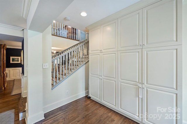 stairs featuring wood finished floors, baseboards, and recessed lighting