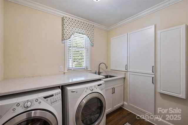 laundry room featuring cabinet space, washing machine and dryer, ornamental molding, and dark wood-style flooring