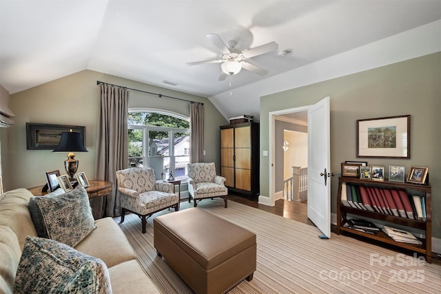 living area featuring lofted ceiling, a ceiling fan, baseboards, and wood finished floors