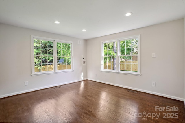 spare room featuring baseboards, wood finished floors, and recessed lighting