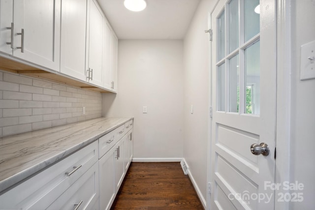 laundry room with dark wood-style floors and baseboards