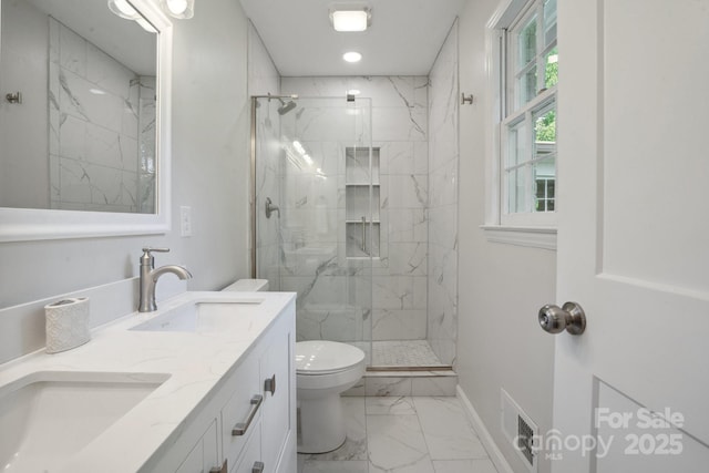 full bath featuring marble look tiles, toilet, a marble finish shower, double vanity, and baseboards