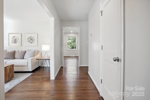 hall with dark wood-style floors and baseboards