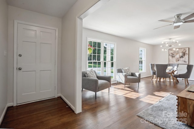 living room featuring dark wood-style floors, baseboards, and a chandelier