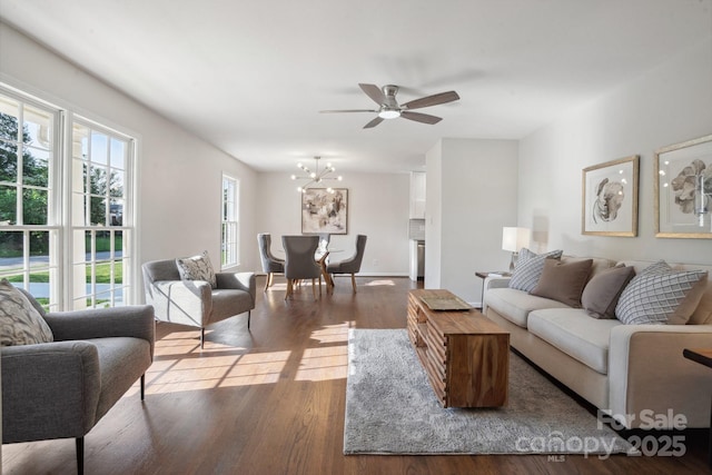 living area featuring wood finished floors, ceiling fan, and a chandelier