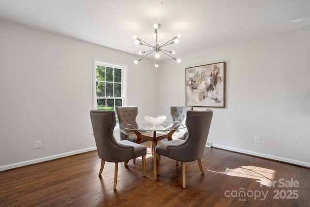 dining space featuring a chandelier, baseboards, and wood finished floors