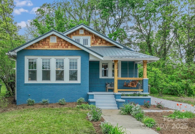 30 Joyner Ave, Asheville, NC 28806 - view of front of house with a standing seam roof, a porch, metal roof, and a front lawn