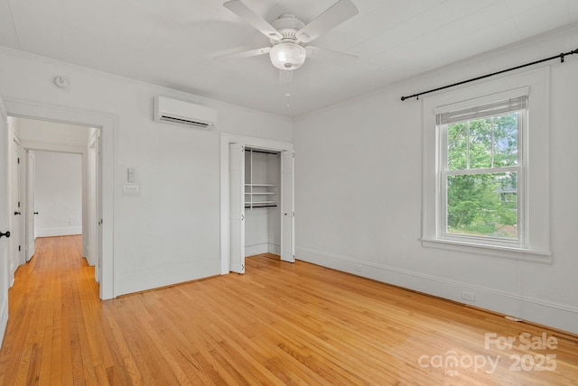 30 Joyner Ave, Asheville, NC 28806 - unfurnished bedroom with a wall mounted AC, light wood-style floors, a closet, baseboards, and ceiling fan