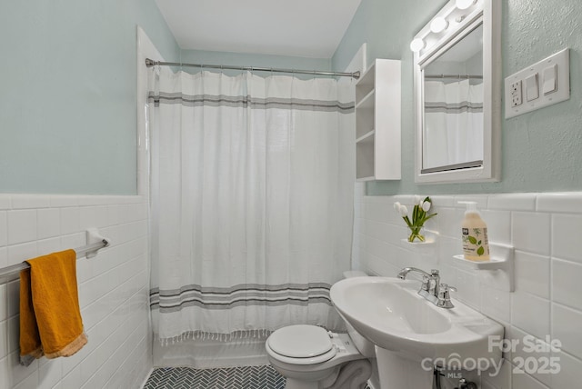 30 Joyner Ave, Asheville, NC 28806 - bathroom with tile walls, a sink, a wainscoted wall, a shower with curtain, and toilet