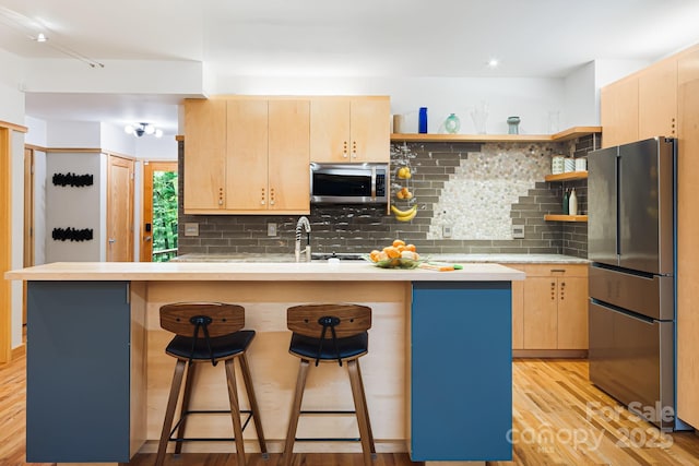 18 Balsam Ct, Arden, NC 28704 - kitchen with appliances with stainless steel finishes, light brown cabinetry, open shelves, and a kitchen breakfast bar