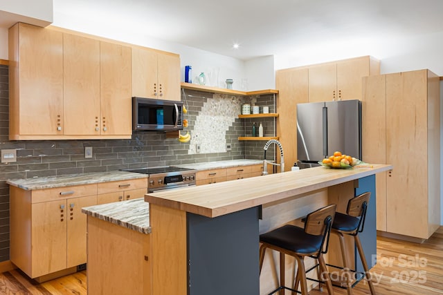 18 Balsam Ct, Arden, NC 28704 - kitchen with stainless steel appliances, light brown cabinets, light wood-style flooring, open shelves, and a breakfast bar