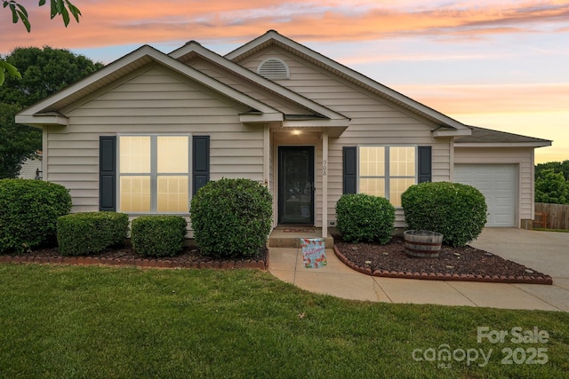 view of front of home featuring an attached garage, concrete driveway, and a lawn