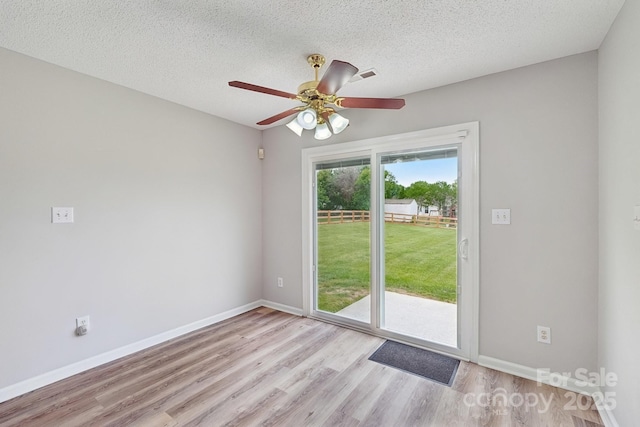 entryway with wood finished floors, a ceiling fan, baseboards, and a textured ceiling
