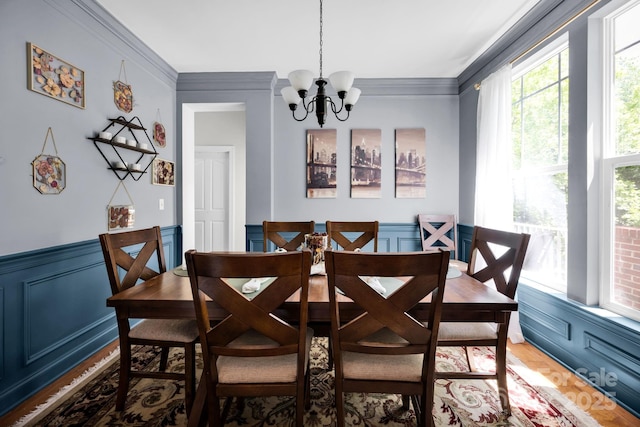 14940 Carbert Ln, Huntersville, NC 28078 - dining room with a chandelier, a decorative wall, ornamental molding, a wainscoted wall, and light wood-style floors