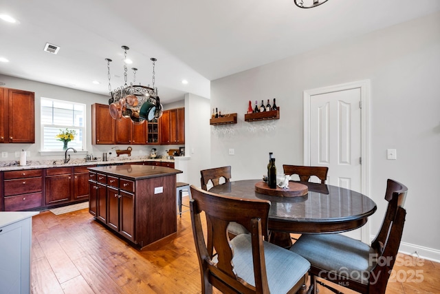 14940 Carbert Ln, Huntersville, NC 28078 - kitchen featuring recessed lighting, light wood finished floors, a center island, glass insert cabinets, and a sink