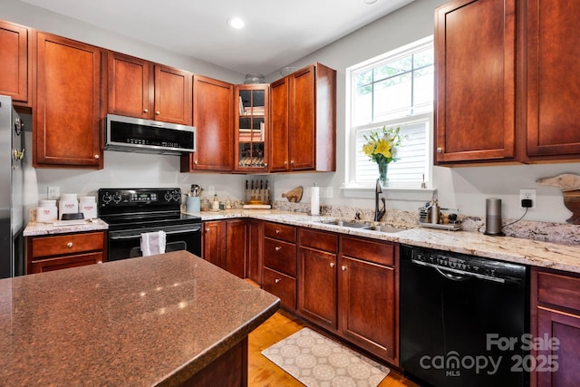 14940 Carbert Ln, Huntersville, NC 28078 - kitchen featuring black appliances, a sink, light wood-style flooring, light stone countertops, and recessed lighting