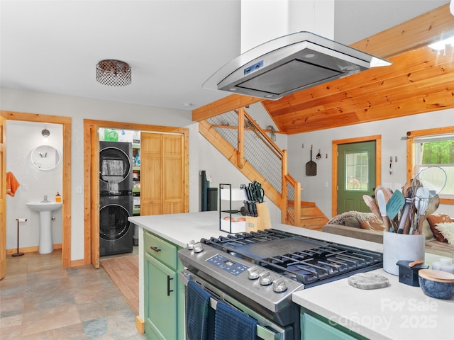 416 Secluded Cv, Waynesville, NC 28785 - kitchen featuring green cabinets, stainless steel range with gas cooktop, stacked washer and clothes dryer, island exhaust hood, and light countertops