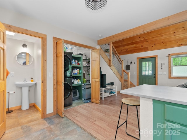416 Secluded Cv, Waynesville, NC 28785 - kitchen featuring stacked washer / drying machine, a kitchen breakfast bar, light countertops, a sink, and baseboards