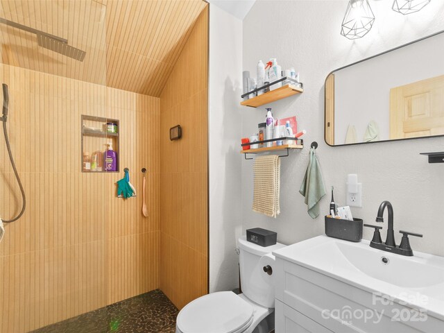 416 Secluded Cv, Waynesville, NC 28785 - bathroom with tiled shower, toilet, vanity, and lofted ceiling