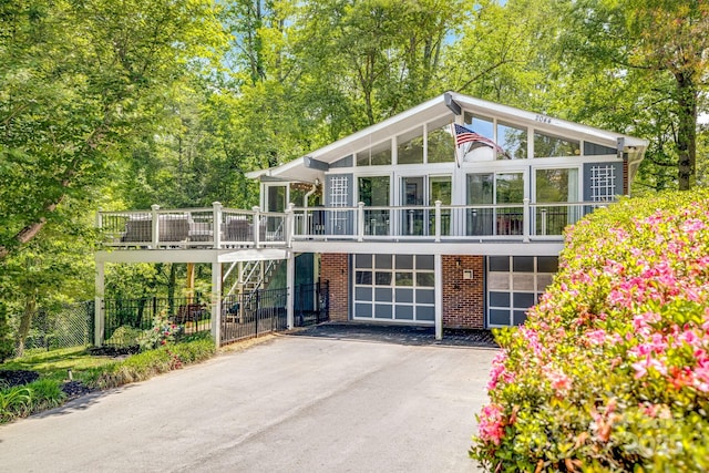 2044 Glenheath Dr, Hendersonville, NC 28791 - mid-century inspired home featuring asphalt driveway, fence, brick siding, a sunroom, and a deck