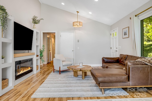 2044 Glenheath Dr, Hendersonville, NC 28791 - living room with vaulted ceiling, light wood-style flooring, a glass covered fireplace, and recessed lighting