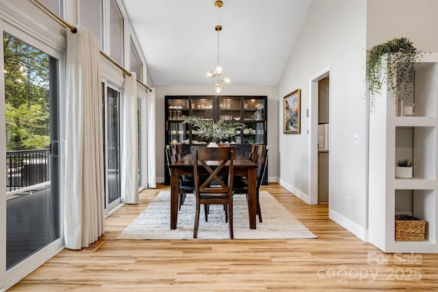 2044 Glenheath Dr, Hendersonville, NC 28791 - dining room featuring light wood-type flooring, a chandelier, plenty of natural light, baseboards, and vaulted ceiling