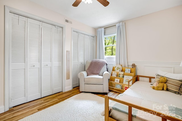 2044 Glenheath Dr, Hendersonville, NC 28791 - bedroom with two closets, wood finished floors, a wainscoted wall, and ceiling fan