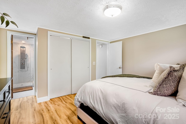 2044 Glenheath Dr, Hendersonville, NC 28791 - bedroom featuring light wood-style floors, a textured ceiling, a closet, connected bathroom, and baseboards