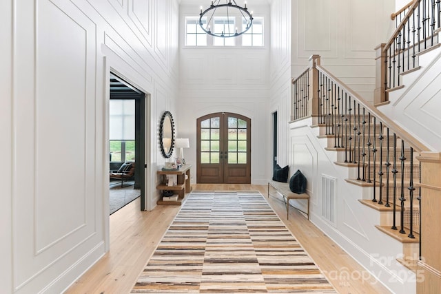 17416 Gillican Overlook Rd, Davidson, NC 28036 - foyer with a decorative wall, stairs, light wood-style floors, french doors, and a towering ceiling