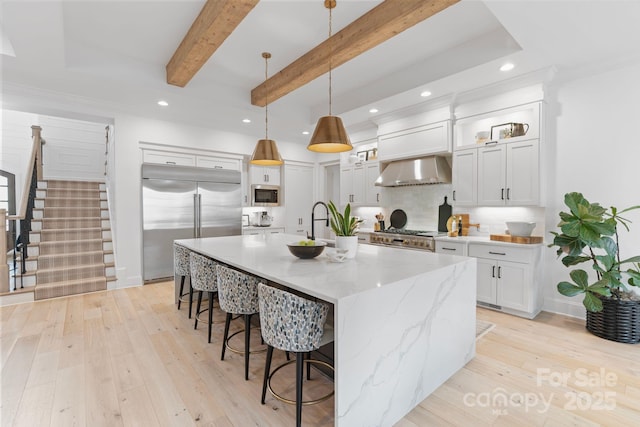 17416 Gillican Overlook Rd, Davidson, NC 28036 - kitchen featuring built in appliances, wall chimney range hood, a kitchen bar, recessed lighting, and backsplash