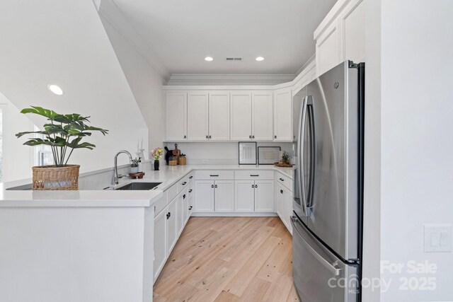 17416 Gillican Overlook Rd, Davidson, NC 28036 - kitchen featuring freestanding refrigerator, a peninsula, light wood-style floors, white cabinetry, and recessed lighting