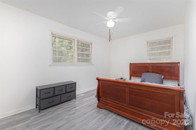bedroom featuring wood finished floors, baseboards, and a ceiling fan