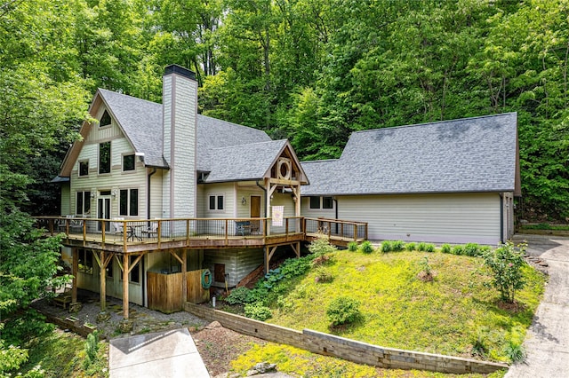 58 Great Aspen Way, Black Mountain, NC 28711 - rear view of house featuring a shingled roof, a wooden deck, a chimney, and a view of trees