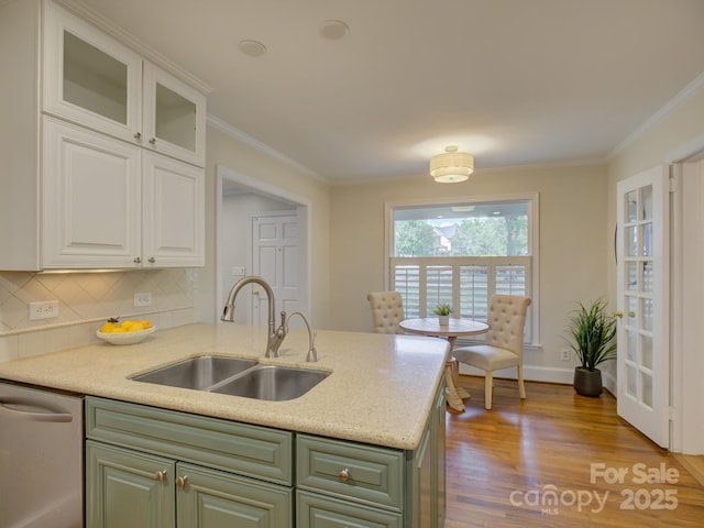 1069 Sedgefield Rd, Charlotte, NC 28209 - kitchen with a sink, stainless steel dishwasher, green cabinetry, ornamental molding, and tasteful backsplash