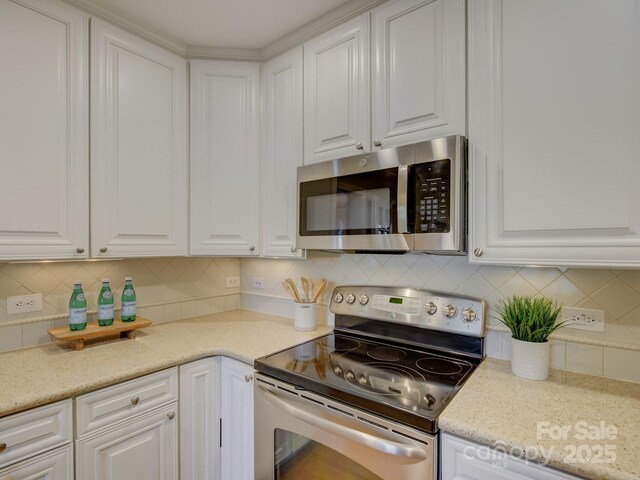 1069 Sedgefield Rd, Charlotte, NC 28209 - kitchen with stainless steel appliances, white cabinetry, and tasteful backsplash