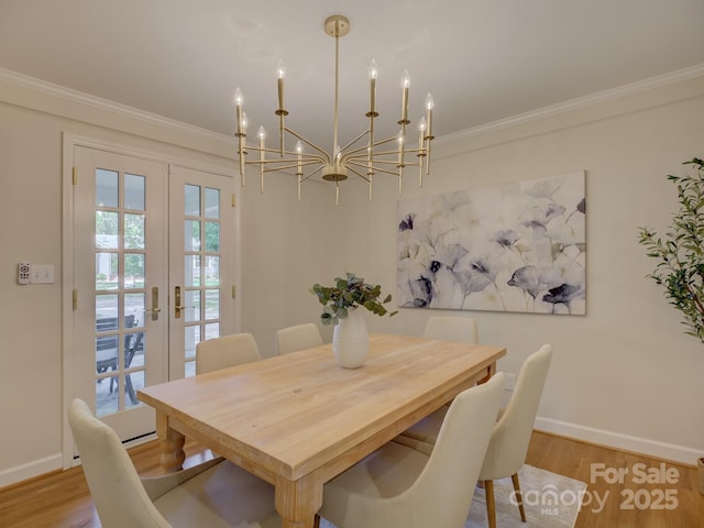 1069 Sedgefield Rd, Charlotte, NC 28209 - dining space featuring french doors, baseboards, ornamental molding, a chandelier, and light wood-style floors