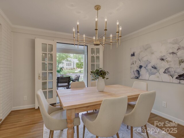 1069 Sedgefield Rd, Charlotte, NC 28209 - dining area featuring a chandelier, wood finished floors, baseboards, and crown molding