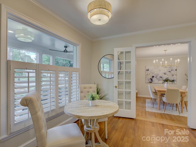 1069 Sedgefield Rd, Charlotte, NC 28209 - dining space featuring ornamental molding, healthy amount of natural light, wood finished floors, a chandelier, and baseboards