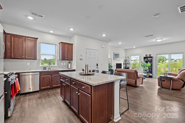 5207 Maynard Hill Dr, Monroe, NC 28110 - kitchen featuring appliances with stainless steel finishes, open floor plan, a sink, a kitchen breakfast bar, and dark wood-style flooring