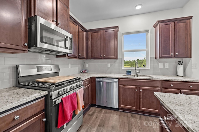 5207 Maynard Hill Dr, Monroe, NC 28110 - kitchen featuring appliances with stainless steel finishes, a sink, dark wood finished floors, backsplash, and light stone countertops
