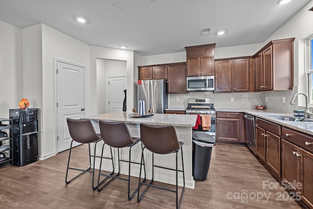 5207 Maynard Hill Dr, Monroe, NC 28110 - kitchen with stainless steel appliances, a sink, a center island, wood finished floors, and recessed lighting