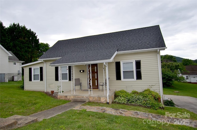 60 3rd St, Marion, NC 28752 - view of front of property with covered porch, a front yard, central AC, and a shingled roof
