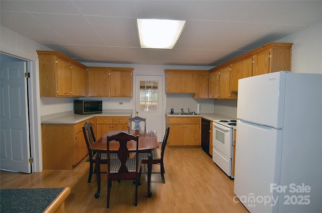 60 3rd St, Marion, NC 28752 - kitchen with white appliances, light wood-style floors, brown cabinetry, light countertops, and a sink