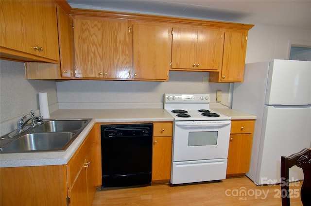 60 3rd St, Marion, NC 28752 - kitchen featuring white appliances, a sink, light countertops, light wood-style floors, and brown cabinetry