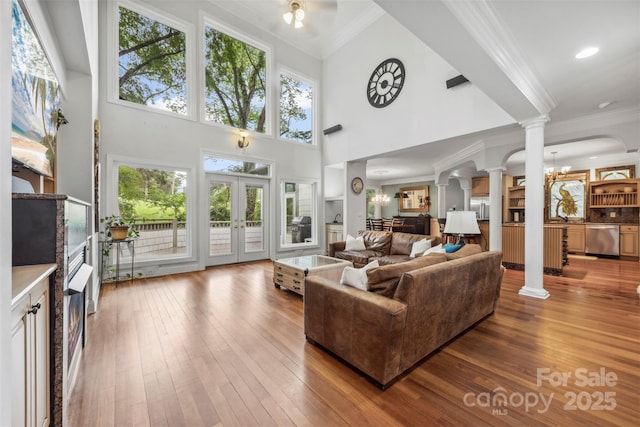 3932 Rounding Run Rd, Charlotte, NC 28277 - living area featuring ornate columns, crown molding, hardwood / wood-style floors, plenty of natural light, and a towering ceiling
