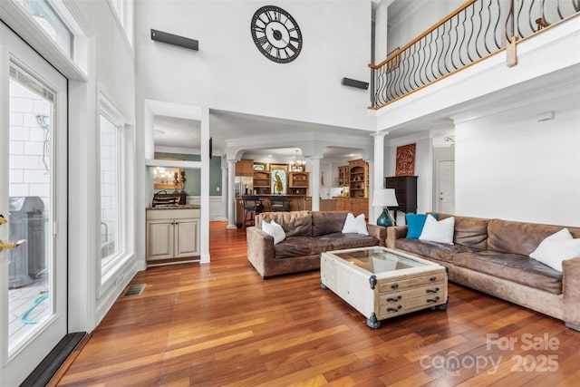 3932 Rounding Run Rd, Charlotte, NC 28277 - living room with ornate columns, a towering ceiling, wood finished floors, and arched walkways